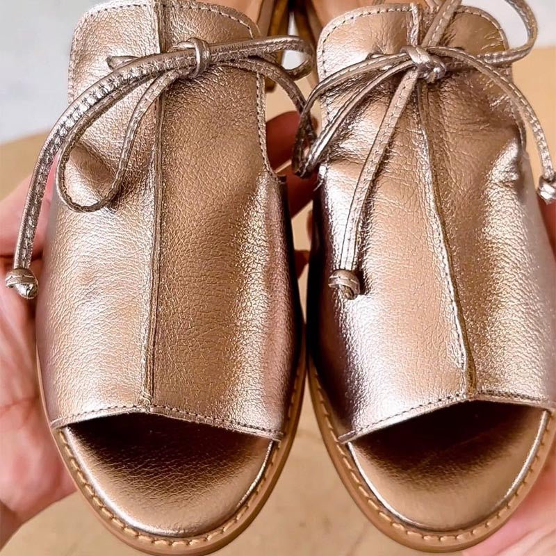 Women's silver metallic flat sandals with bow tie straps and open toe