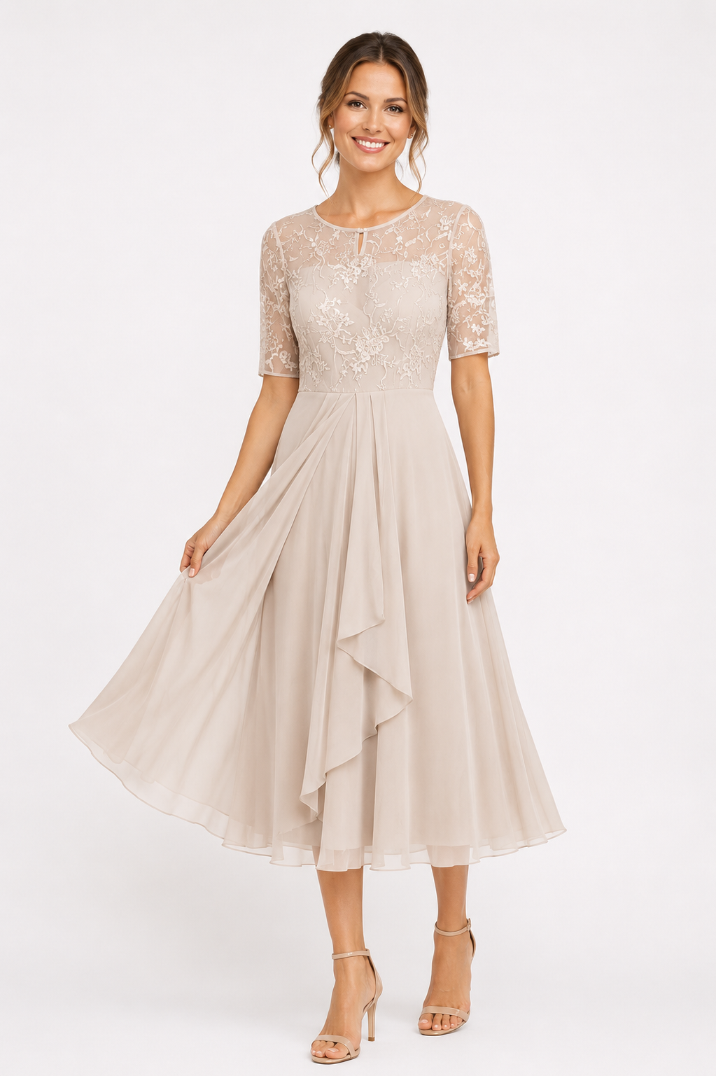 A woman modeling a light beige midi dress with a lace bodice, short sleeves, and a flowing layered skirt, paired with nude high-heeled sandals against a plain white studio background.
